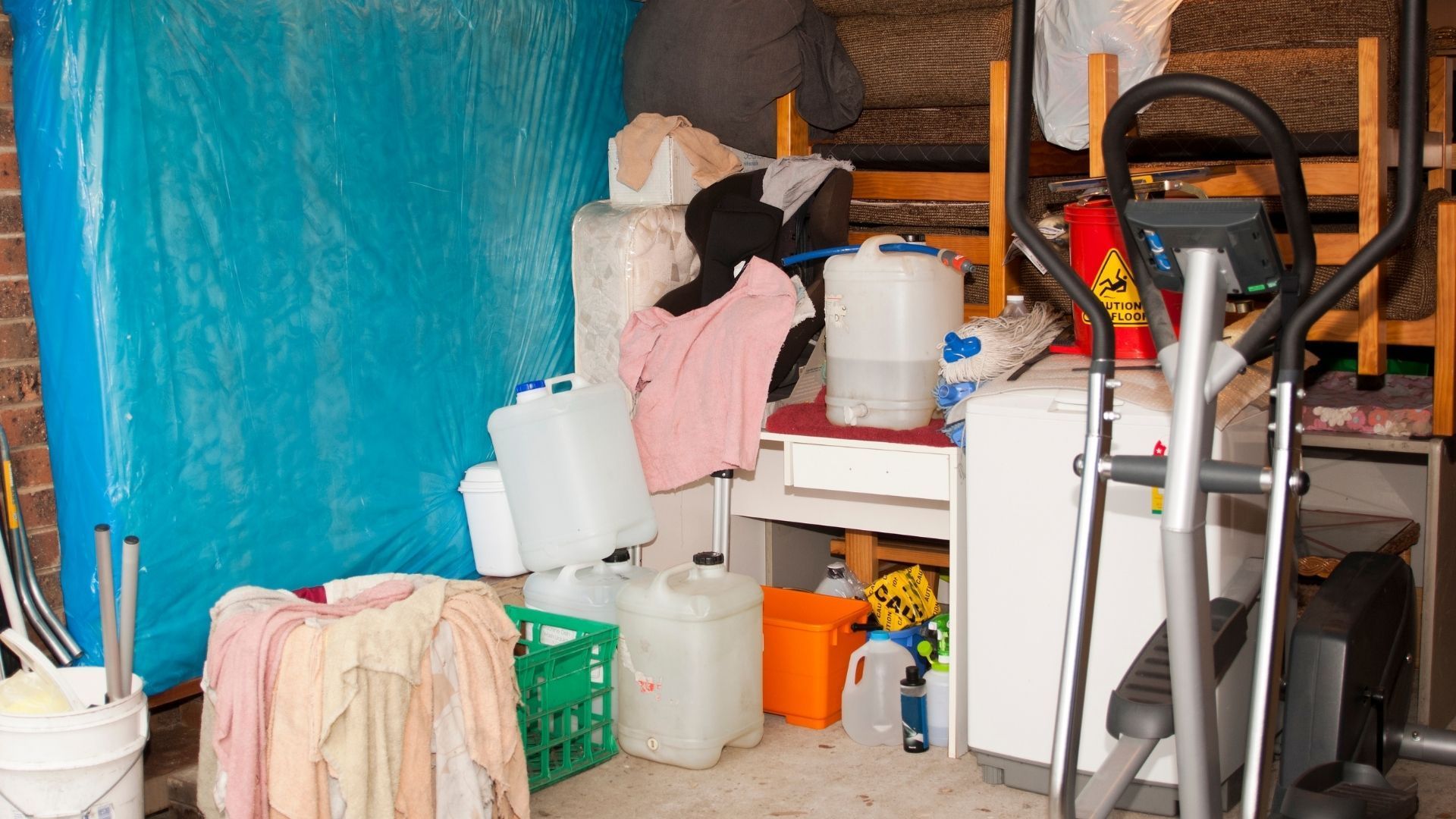 A garage filled with lots of cleaning supplies and a washing machine.