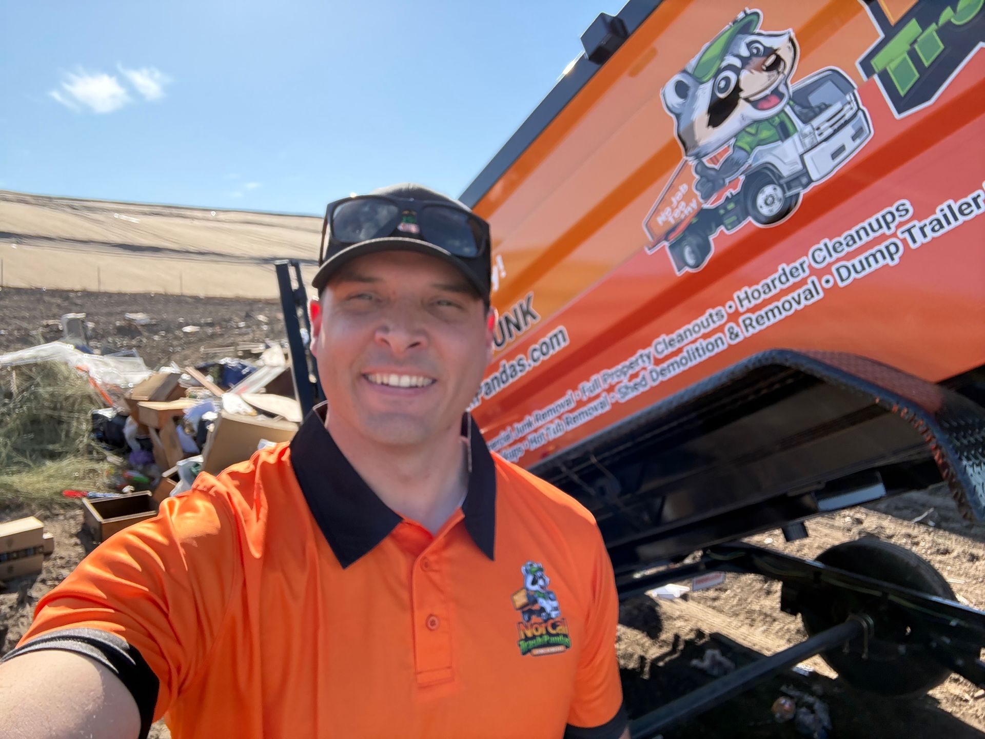 A man is standing in front of a truck with his arms crossed.
