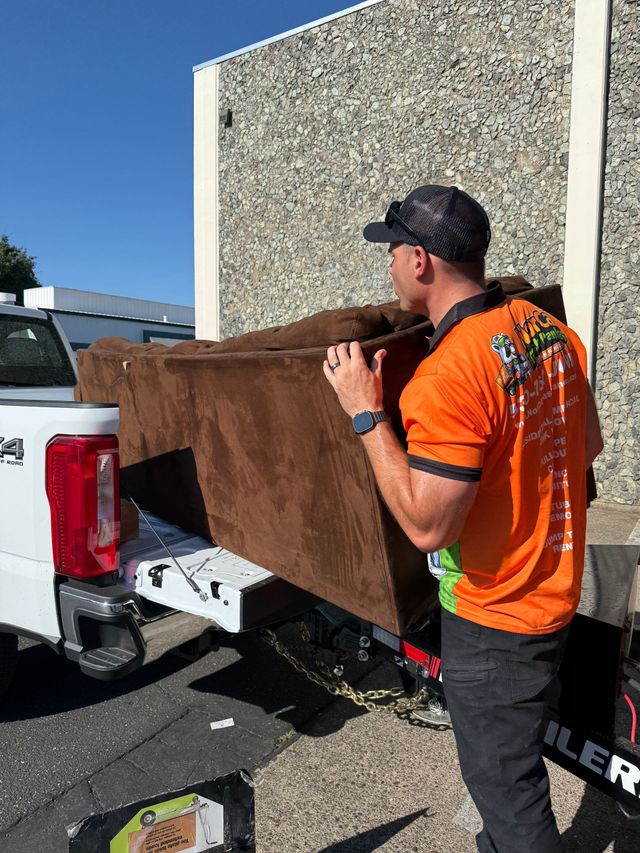 A man is working on the back of a ram truck.