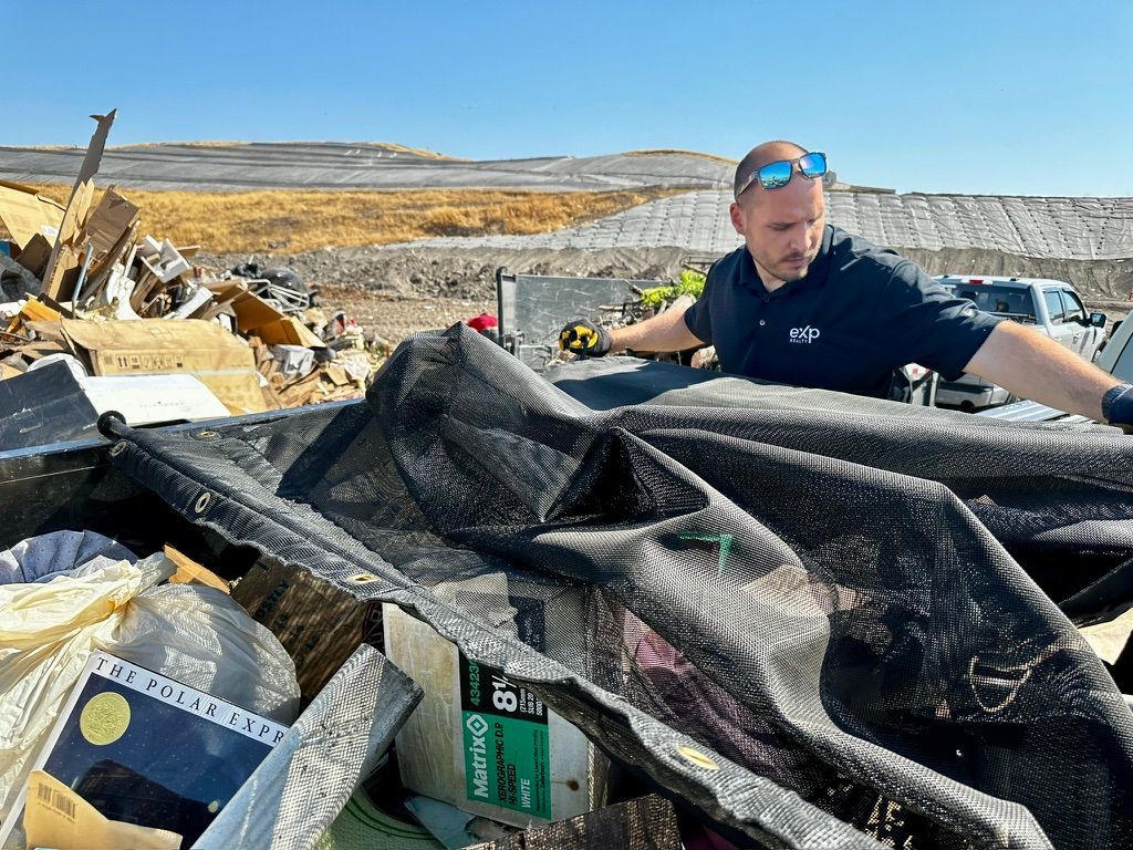 A man is standing in front of a pile of trash.