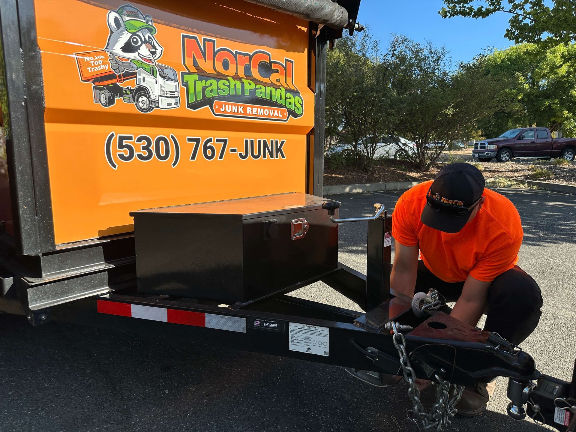 A man is standing in front of a pile of trash.