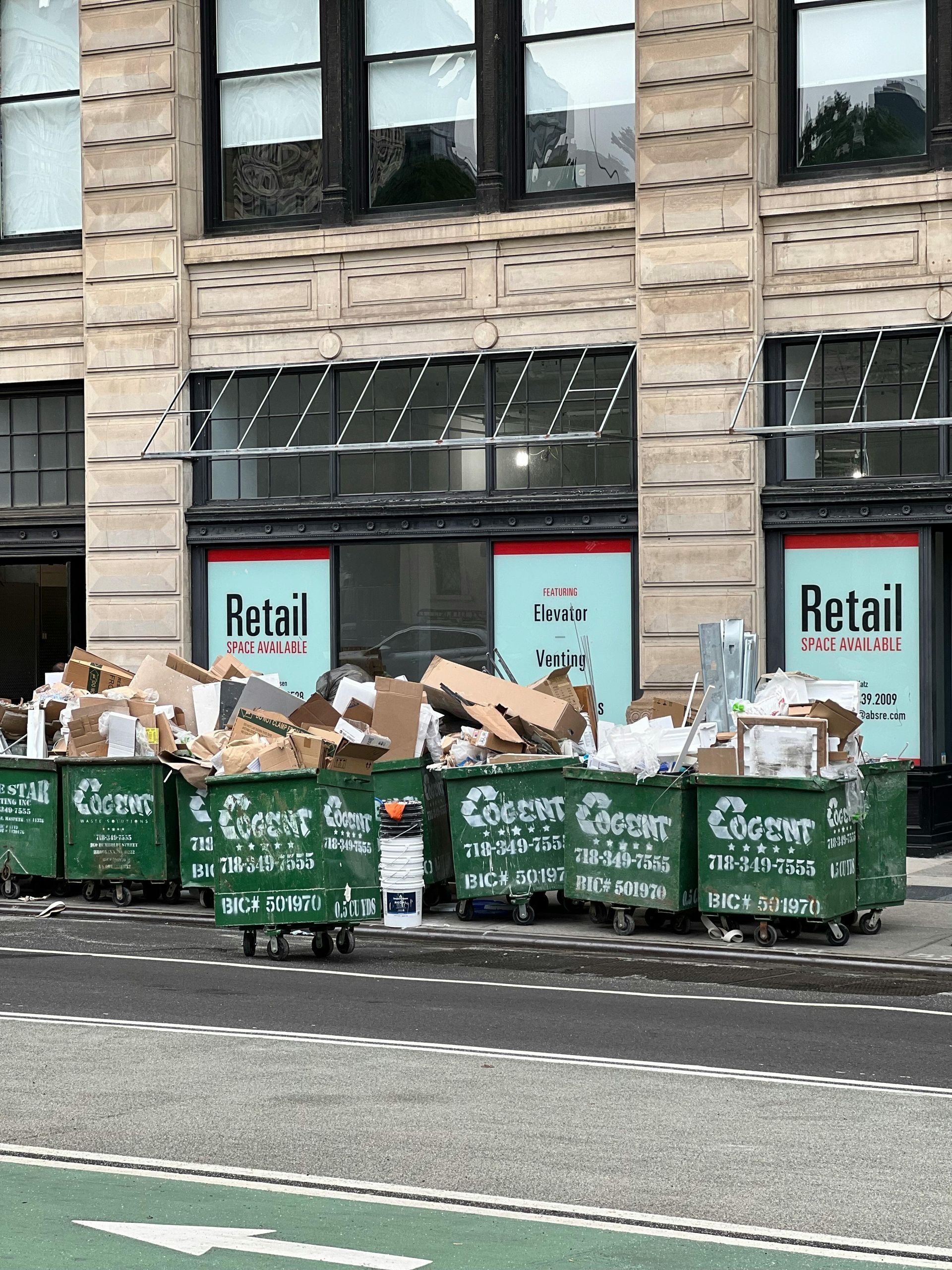 A building with a lot of garbage bins in front of it