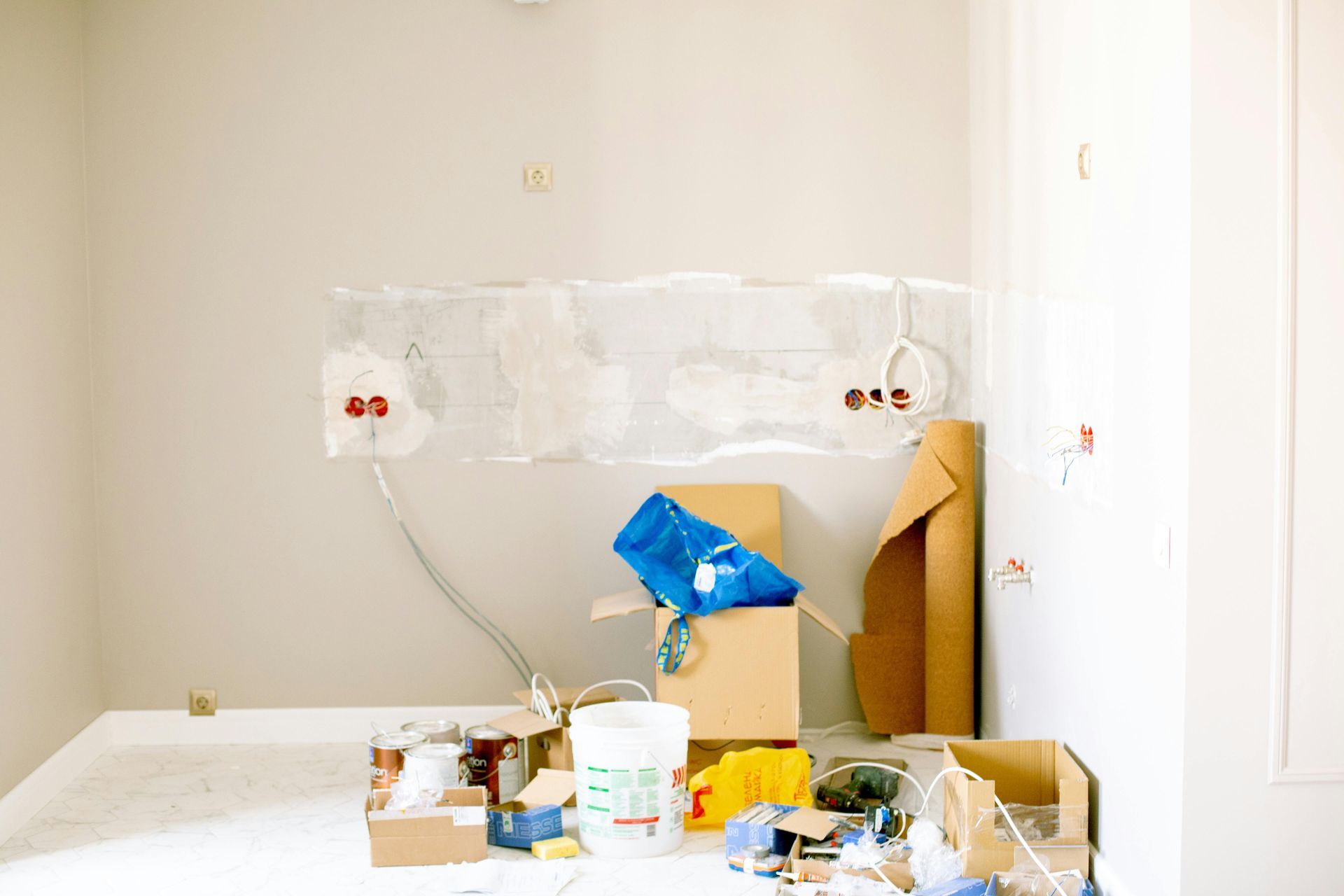 A room with a lot of boxes and buckets on the floor.