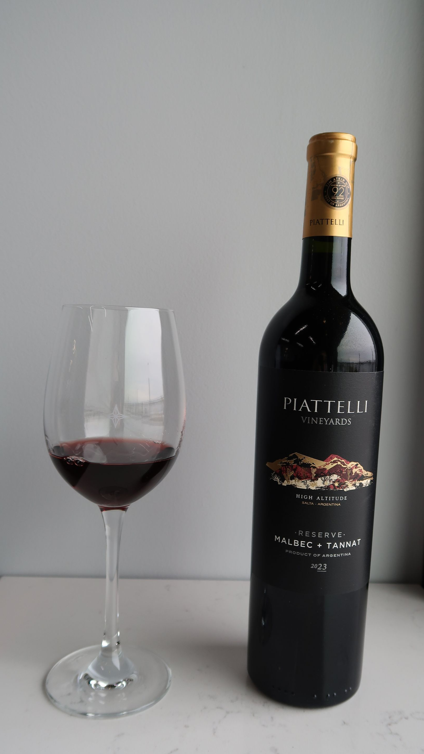 People toasting with wine glasses at a candlelit dinner, with food and a bottle of wine on the table.