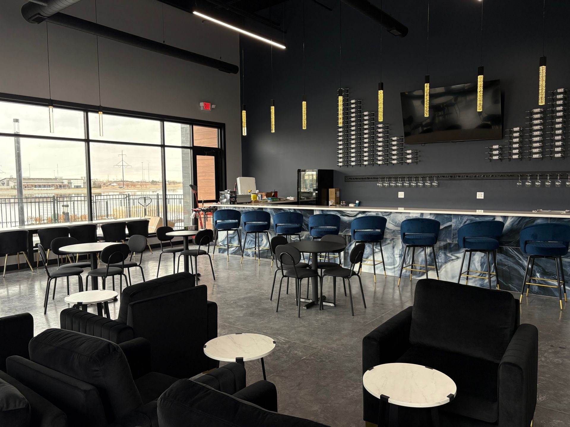 People at a table in a dimly lit restaurant, some holding wine glasses, engaged in conversation.