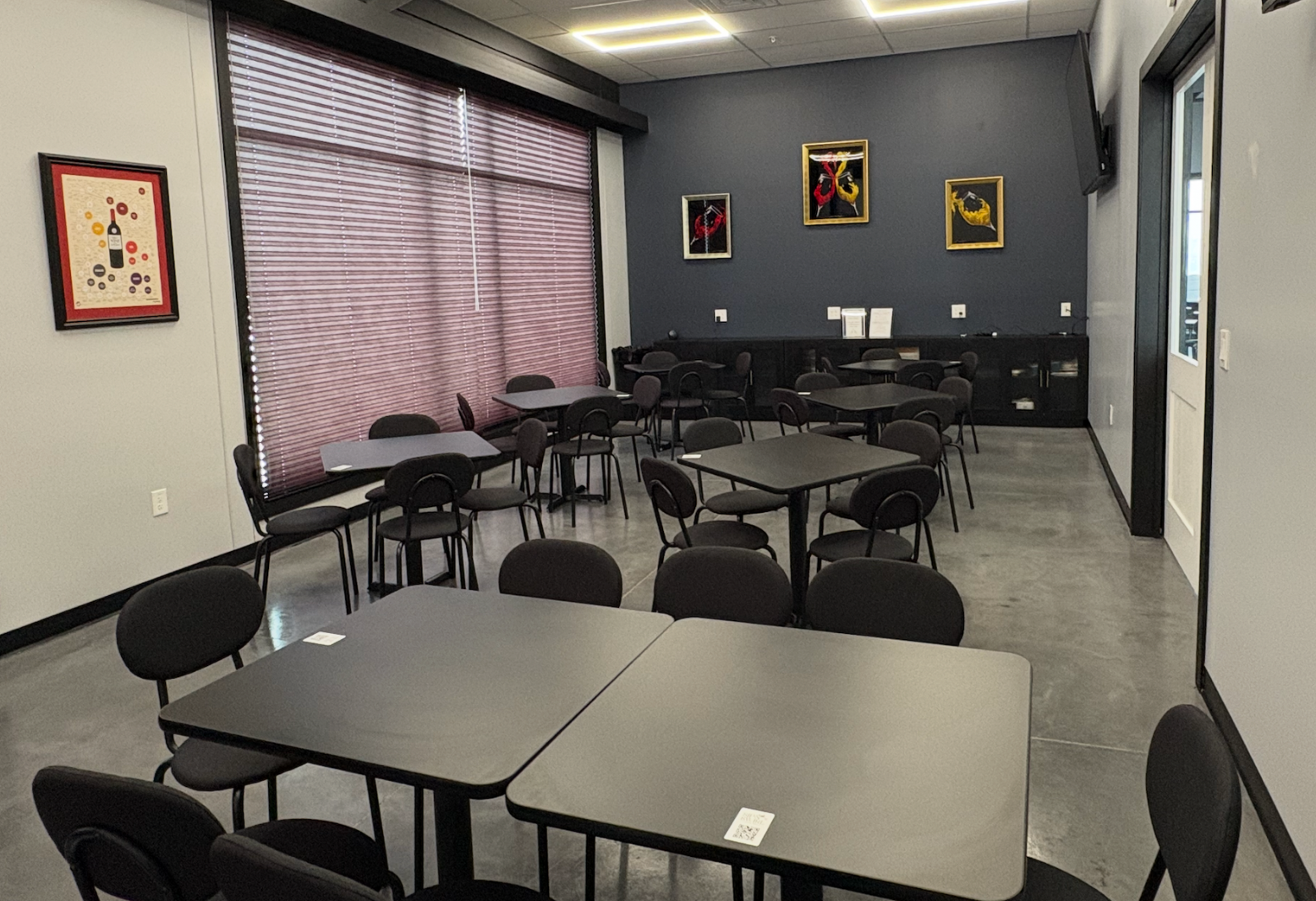 Two wine glasses, one red, one white, near a platter of appetizers in a festive setting.