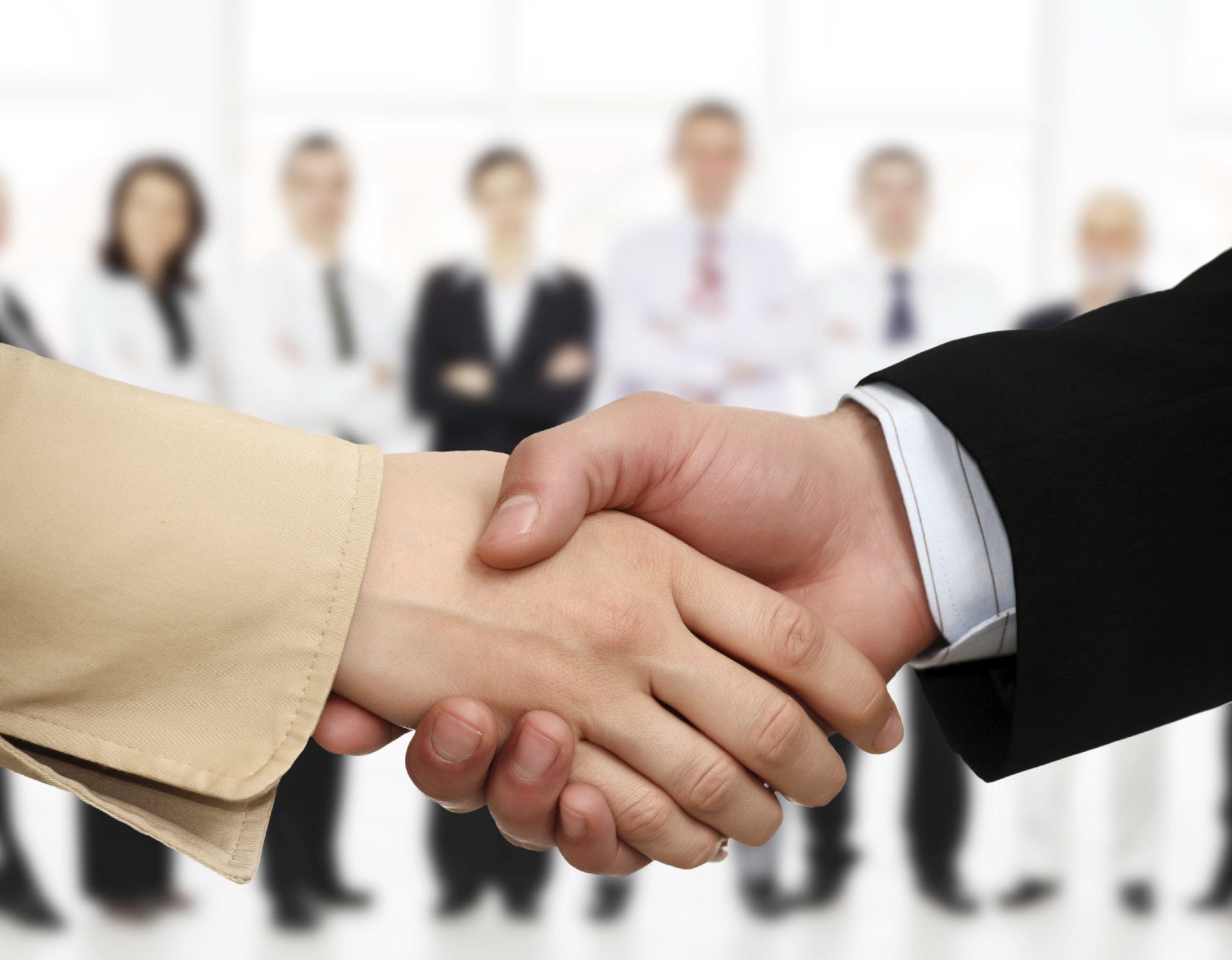 Close-up of business people`s arms handshaking.