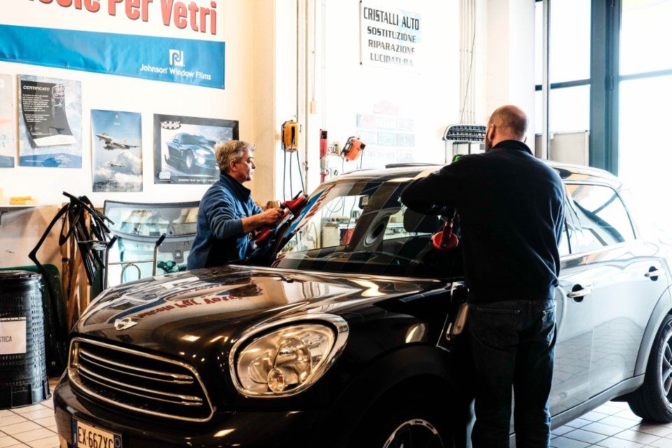 interni sede con operai mentre sostituiscono un parabrezza