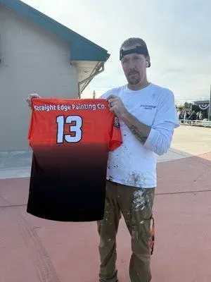 Man holding an orange/black jersey with 