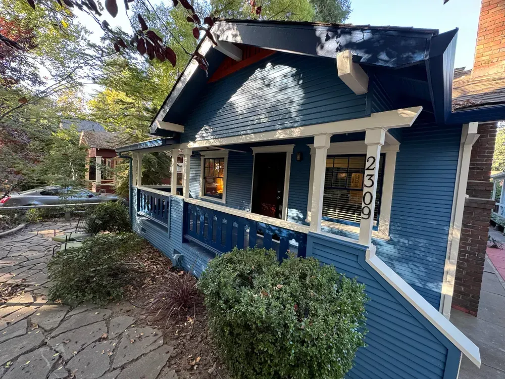 Blue Craftsman house with white trim and stone path; 