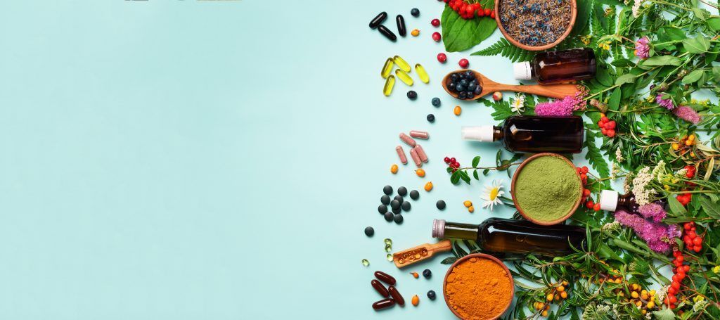 There are many different types of herbs and spices on a blue background.