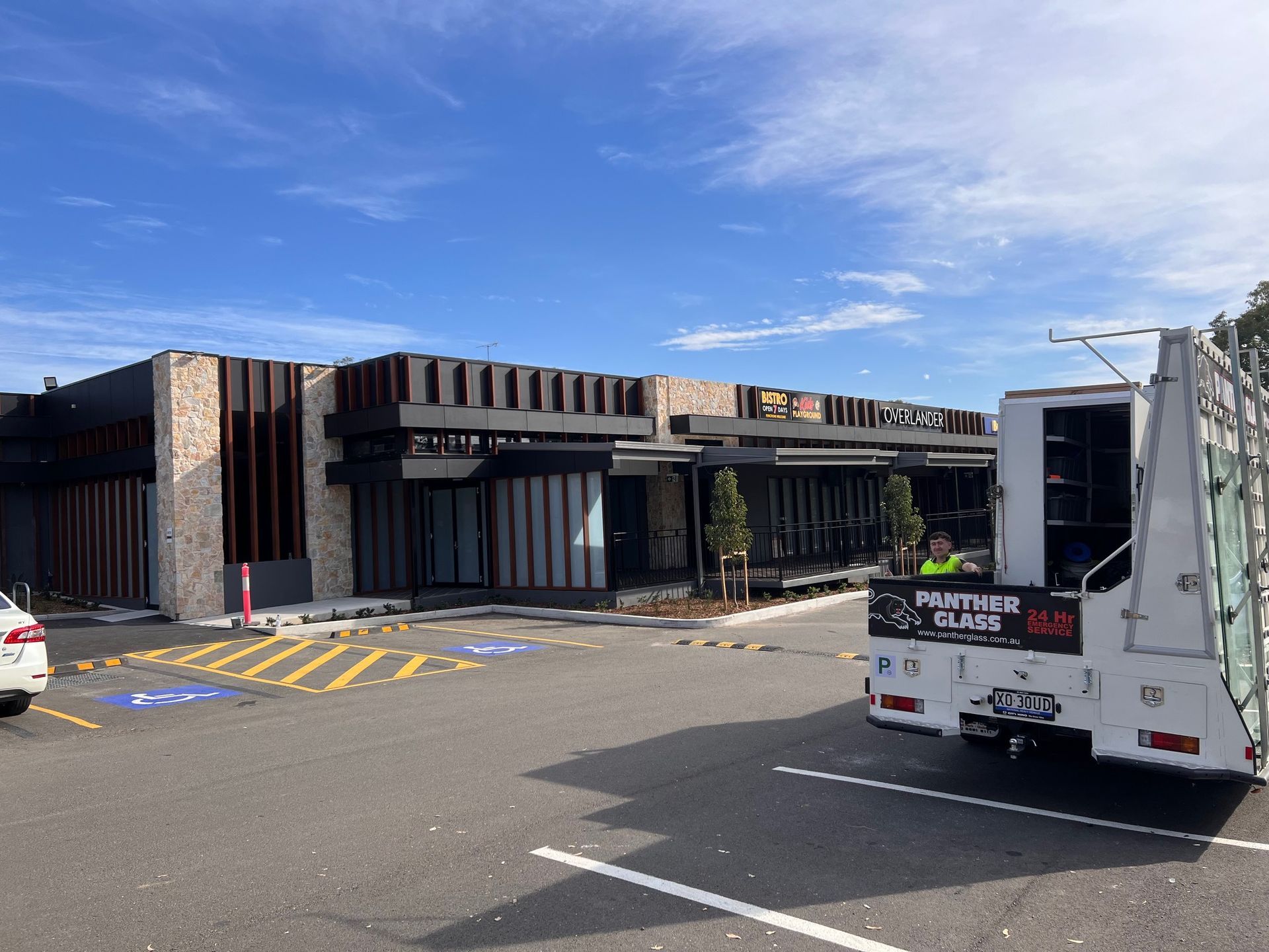 A white truck is parked in front of a building in a parking lot — Penrith, NSW — Panther Glass & Aluminum
