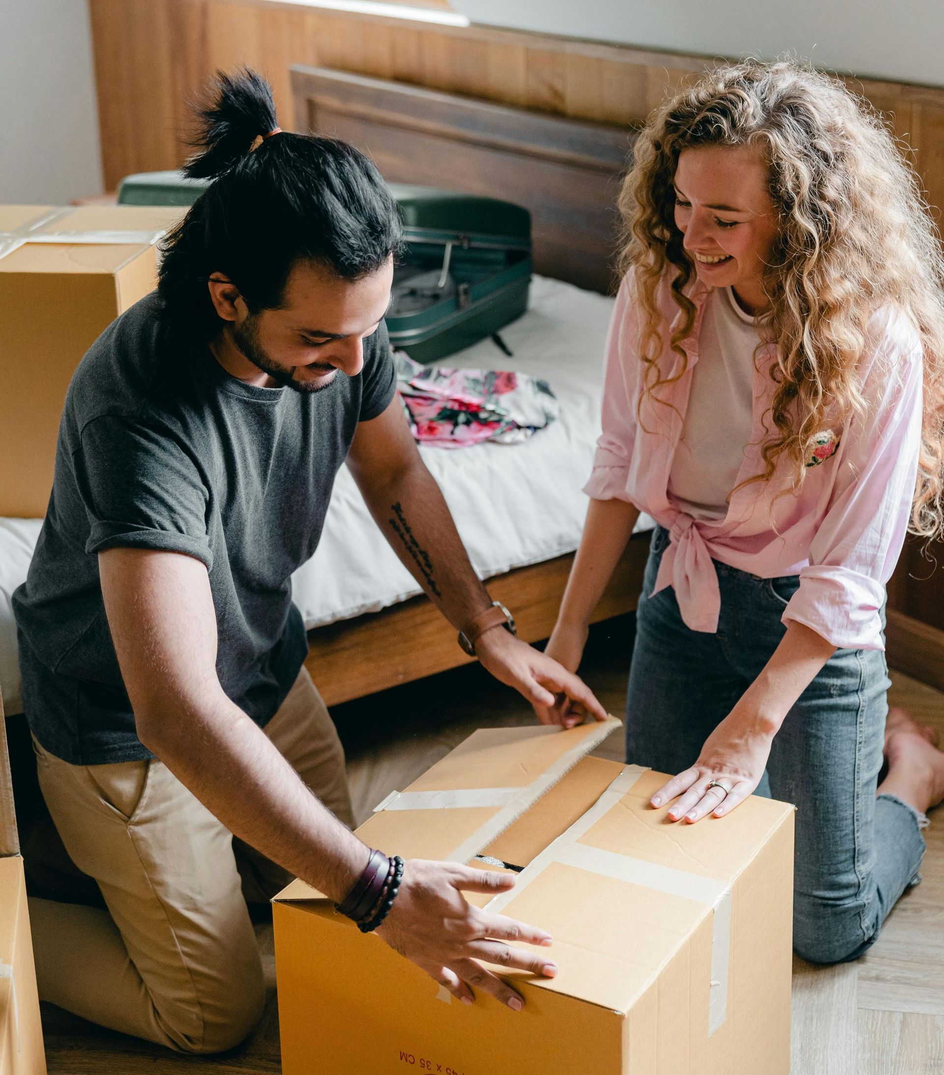A couple packing a moving box together.