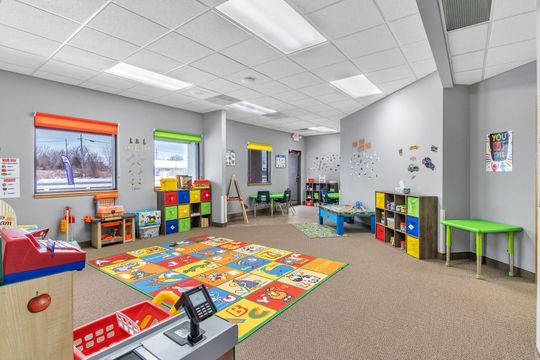 A large room filled with lots of toys and a rug.