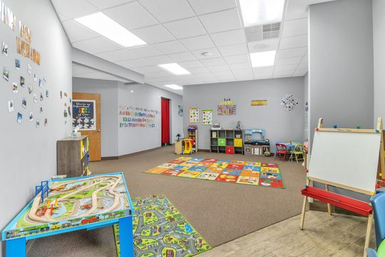 A large room filled with lots of toys and tables.