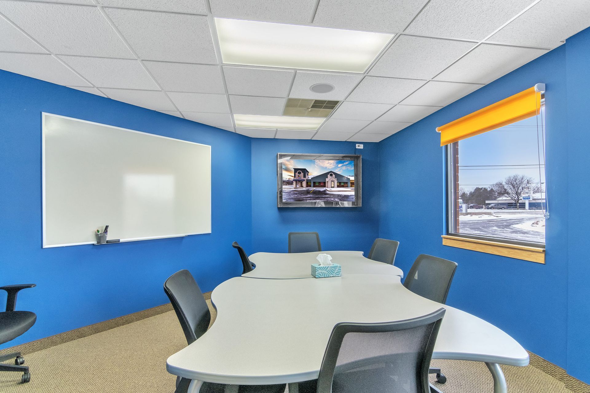 A conference room with blue walls and a round table and chairs