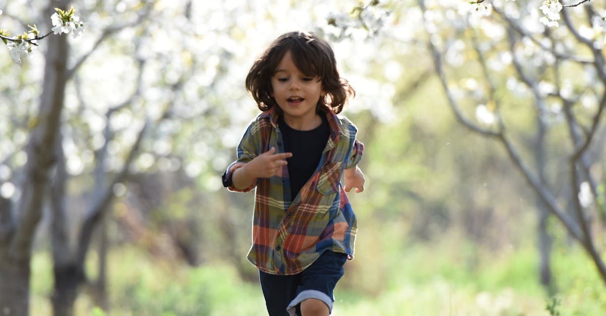 A little boy is running through a forest.