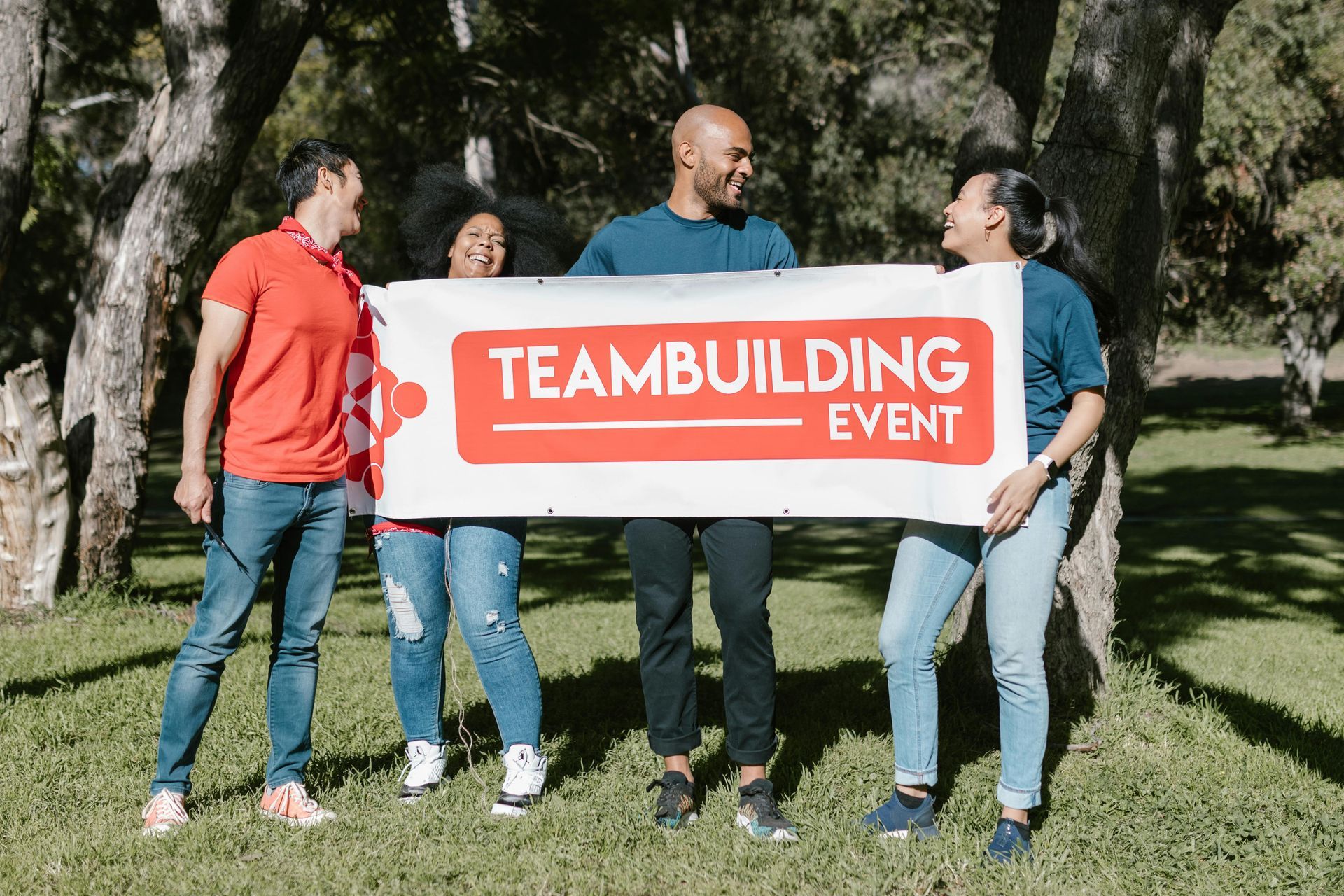 small group of four people holding a banner with text that reads 'teambuilding event'