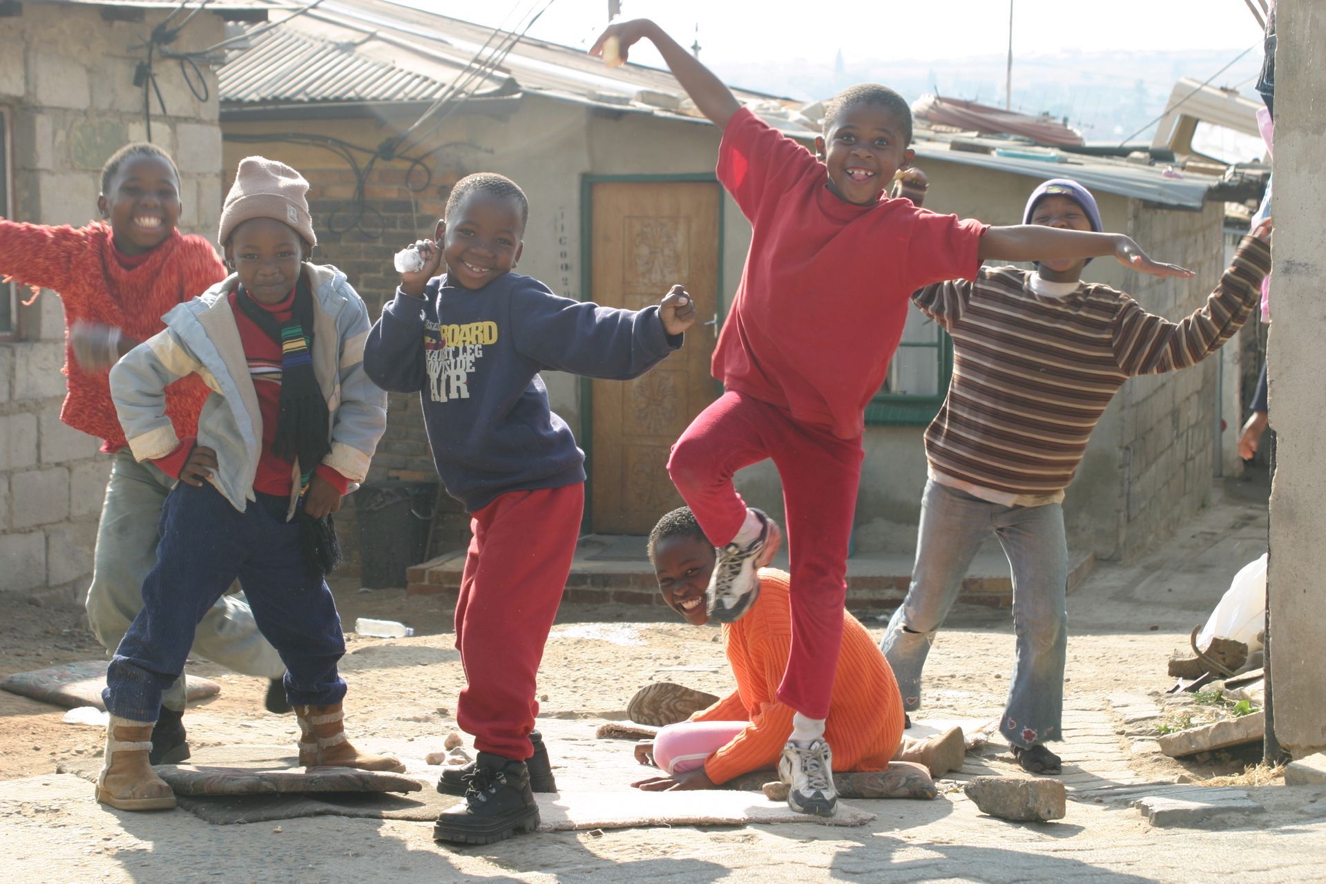 A group of children are posing for a picture in front of a building