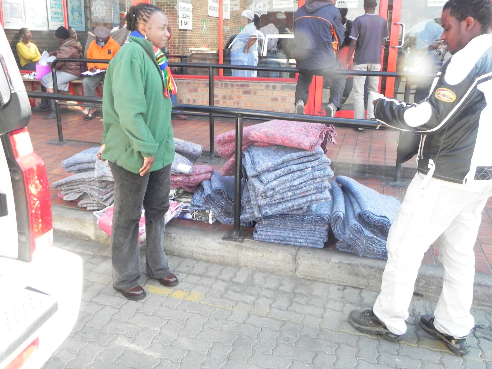 A woman in a green jacket is standing next to a man in a black jacket