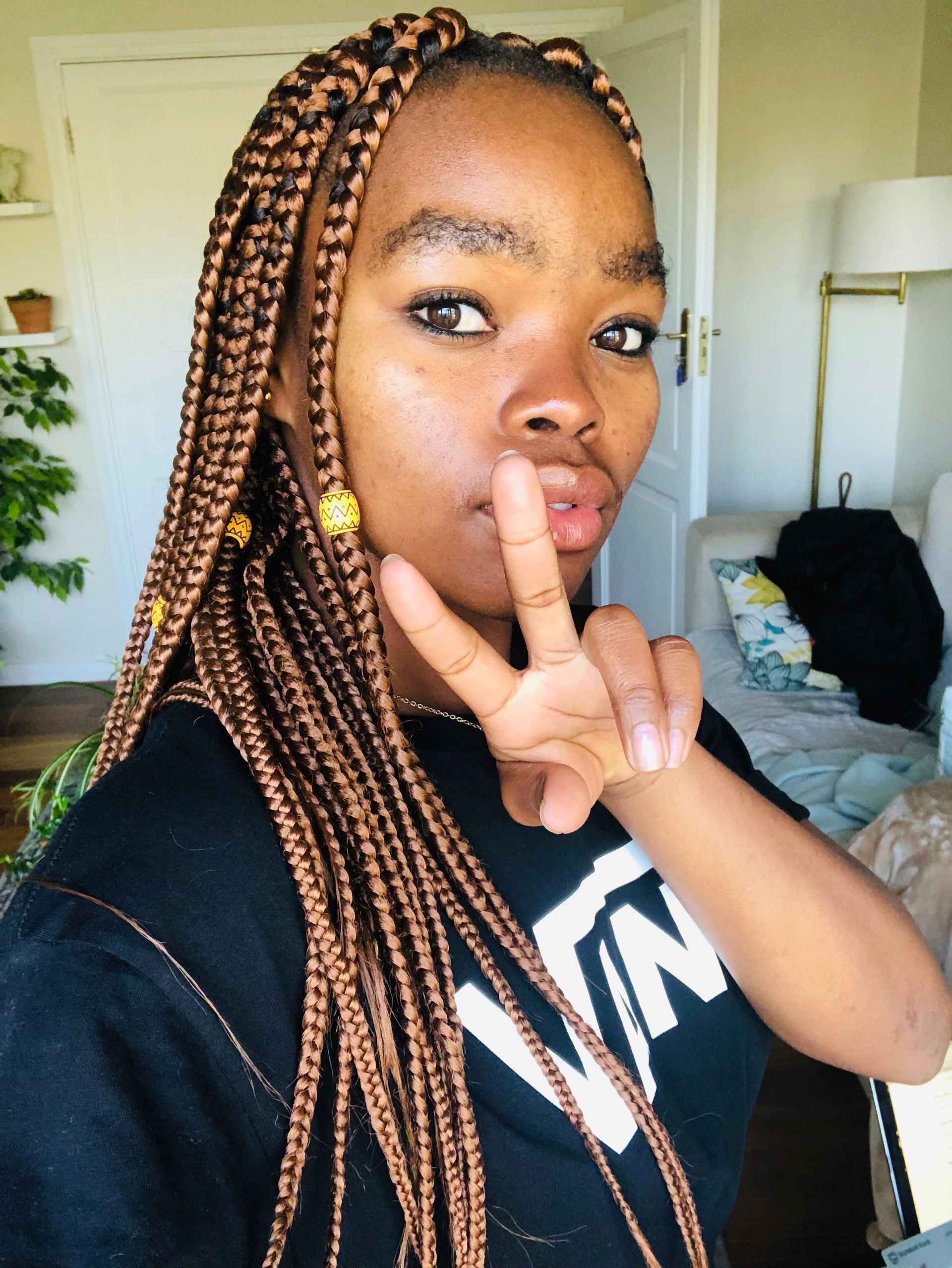 A woman with braids is wearing a black vans shirt