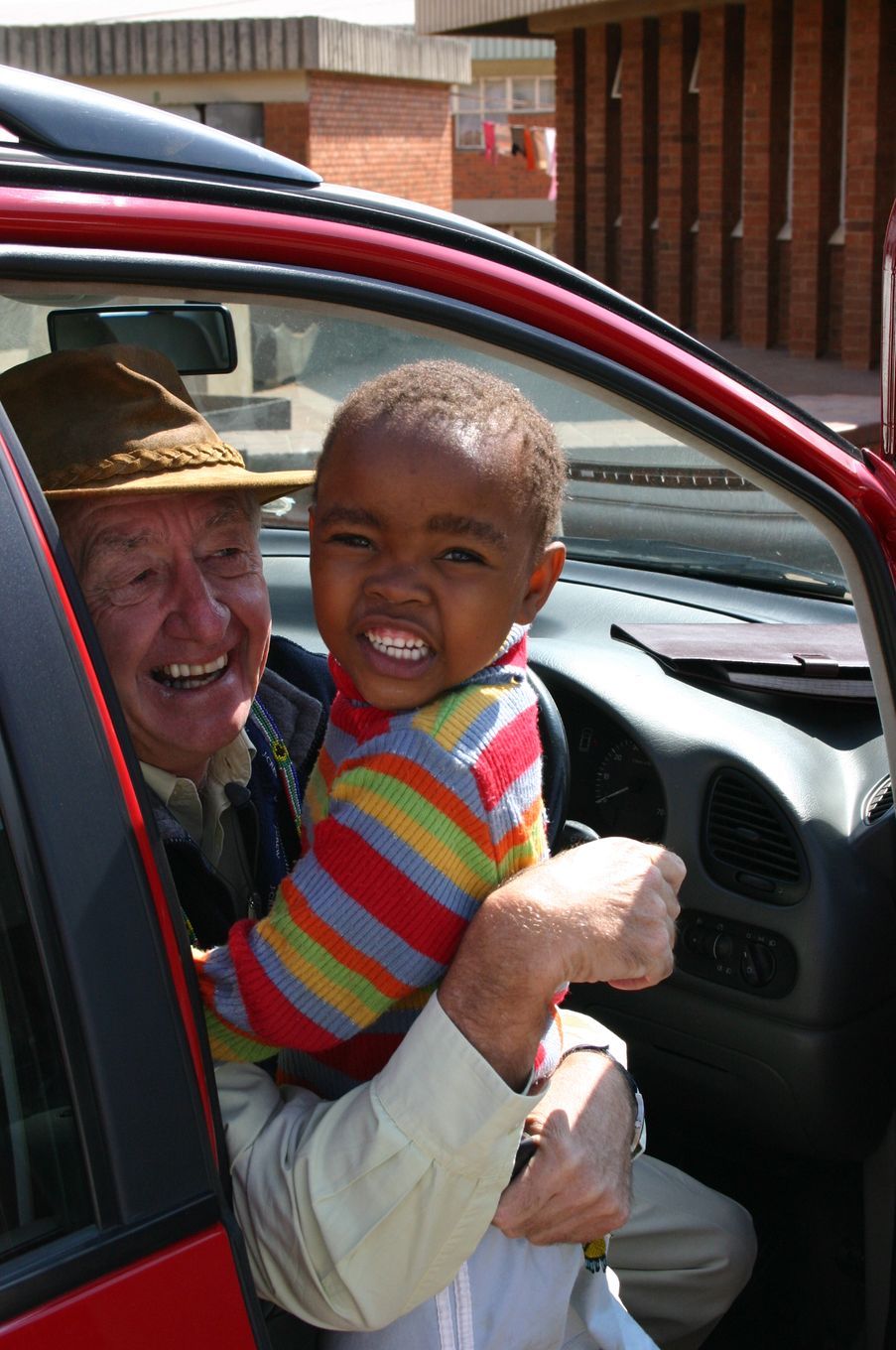 A man is holding a child in his arms in a car