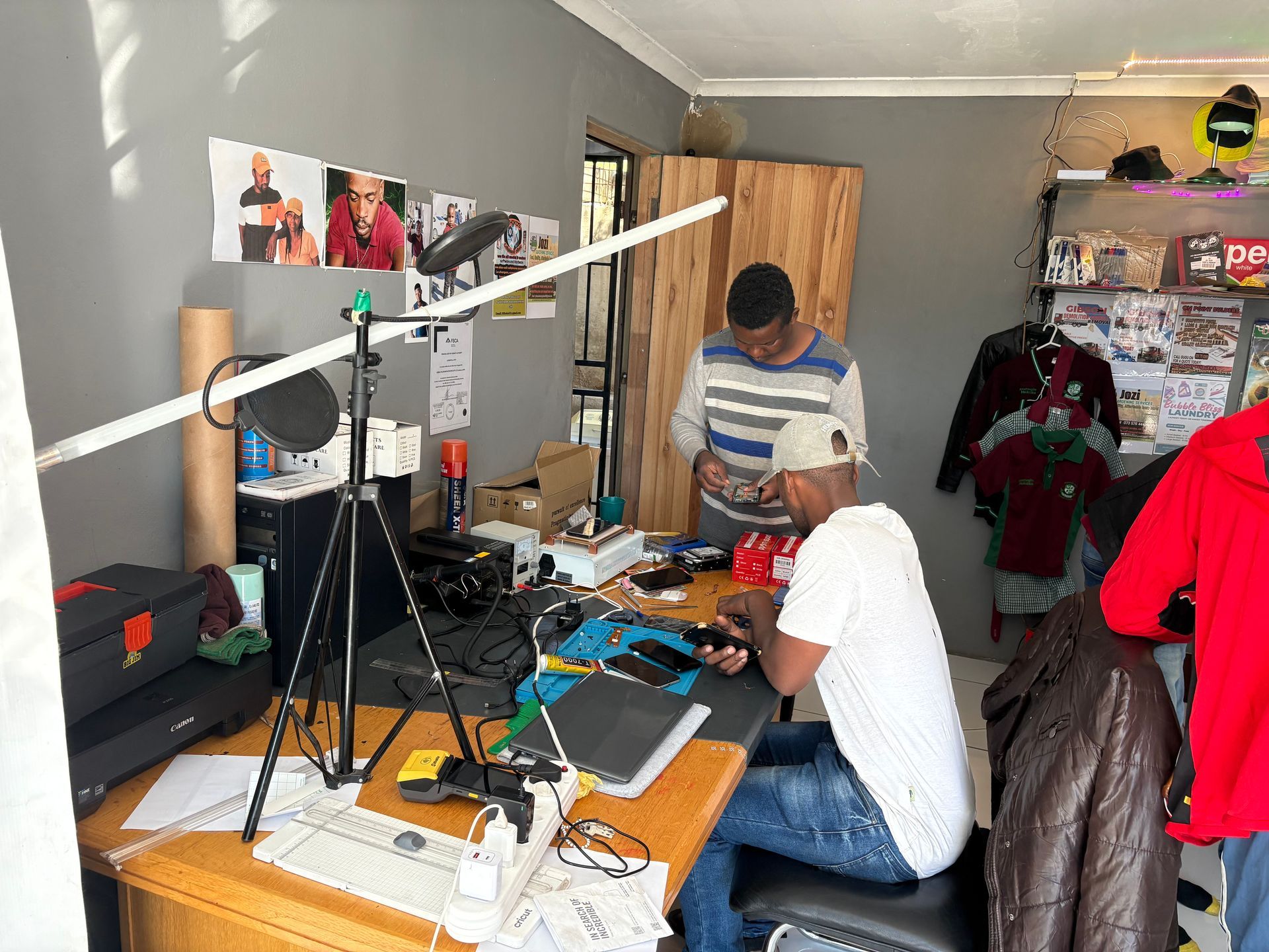 A man is sitting at a desk in front of a computer in a room.