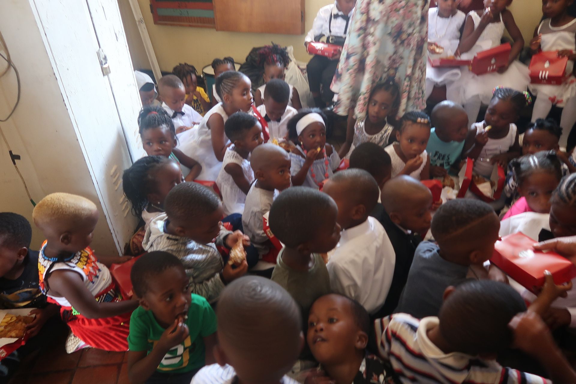 A group of children are sitting on the floor in a room.
