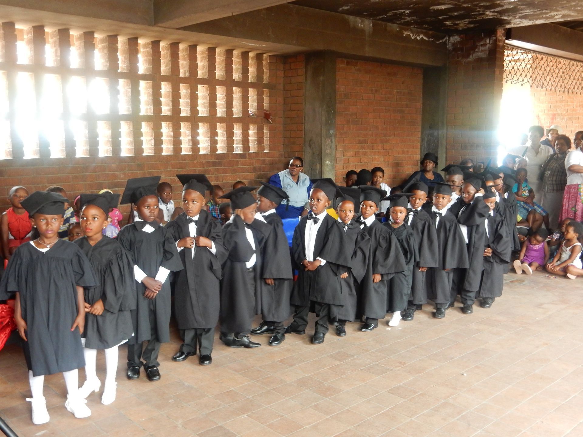 A group of children wearing graduation gowns and caps