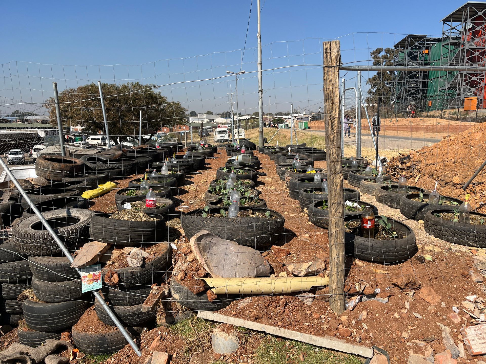 A bunch of tires are stacked on top of each other in a garden.