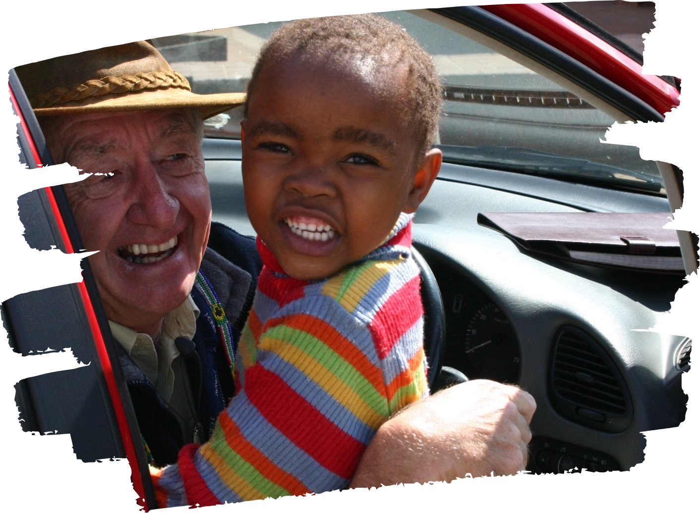 A man in a hat is holding a child in his arms
