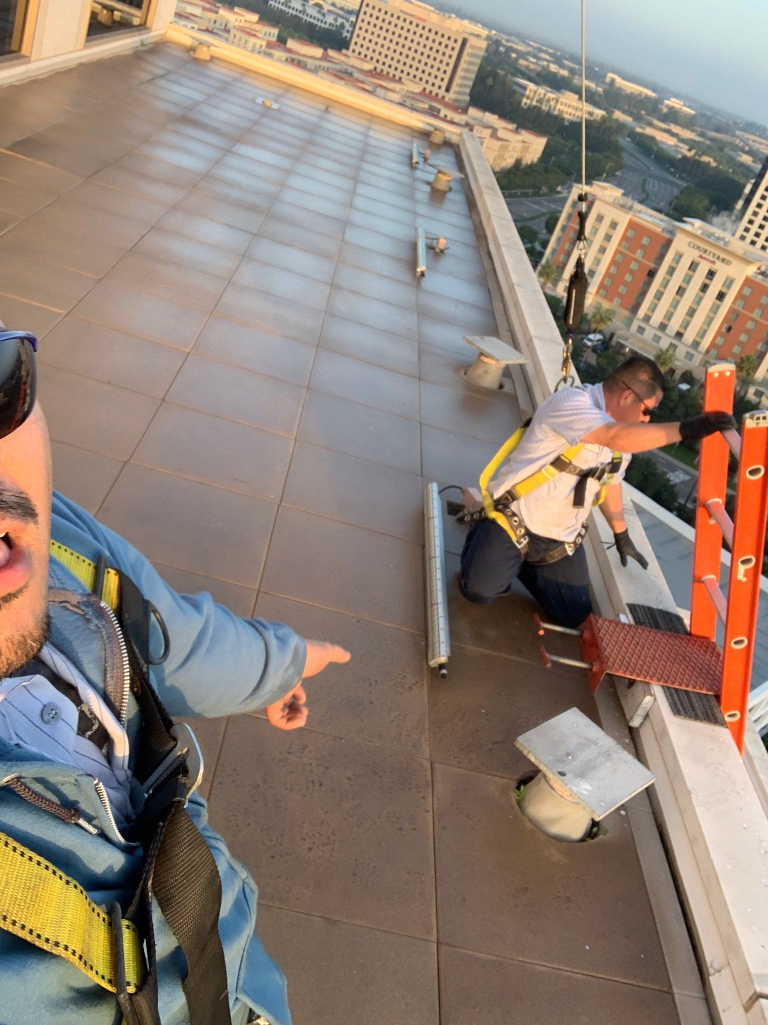 Two men are working on the roof of a building.