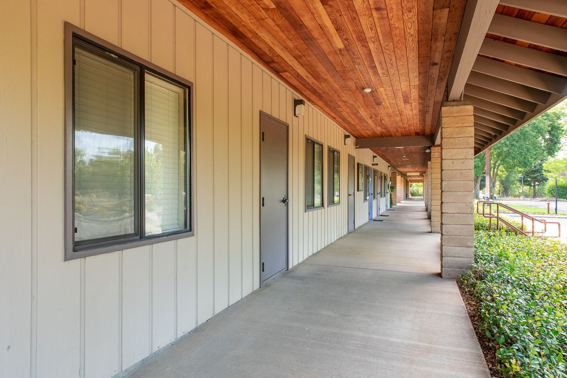 A long hallway between two buildings with a wooden ceiling.