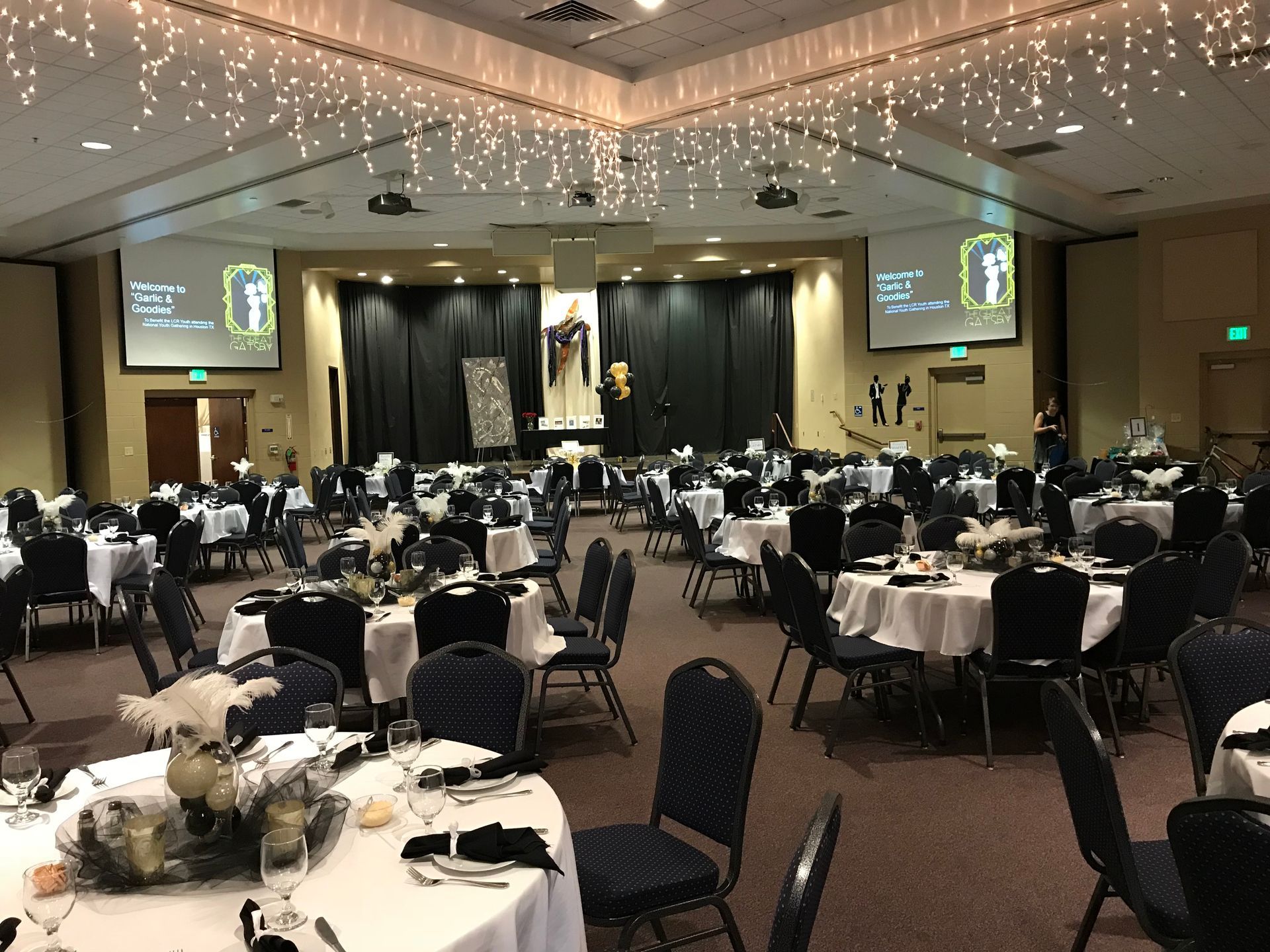 A large room with tables and chairs set up for a wedding reception.