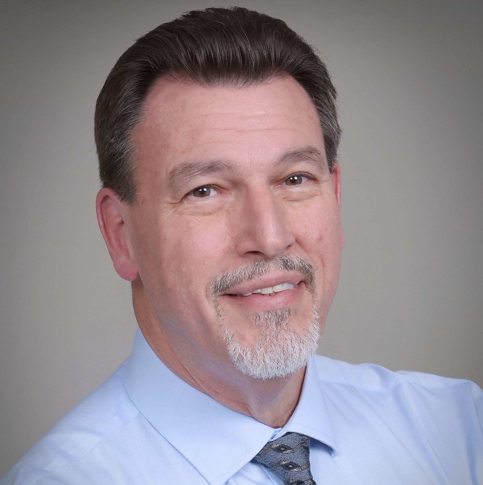 John Cameron is wearing a blue shirt and tie.