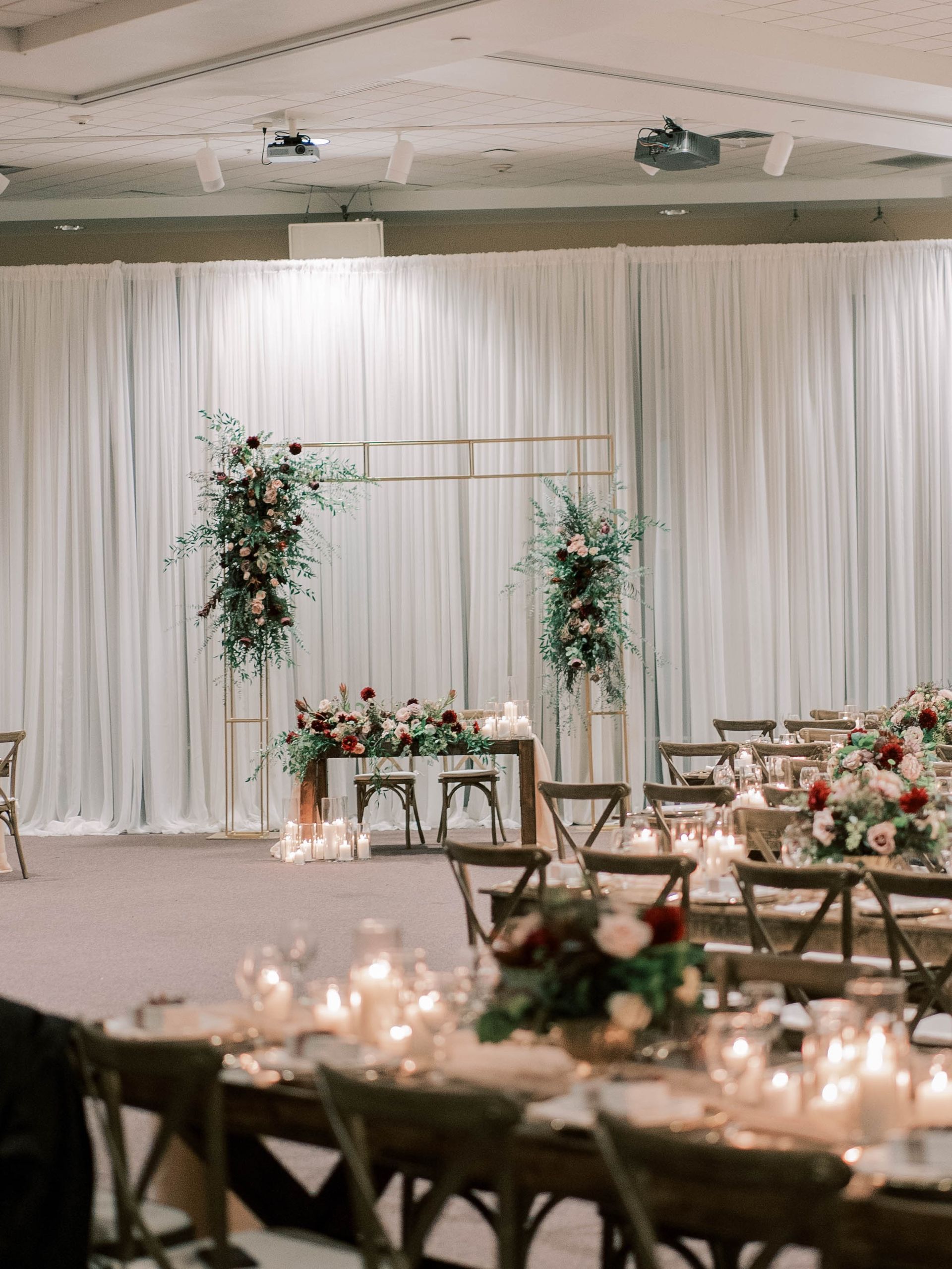 A large room with tables and chairs set up for a wedding reception.