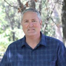 Pastor Derek standing in front of a tree.