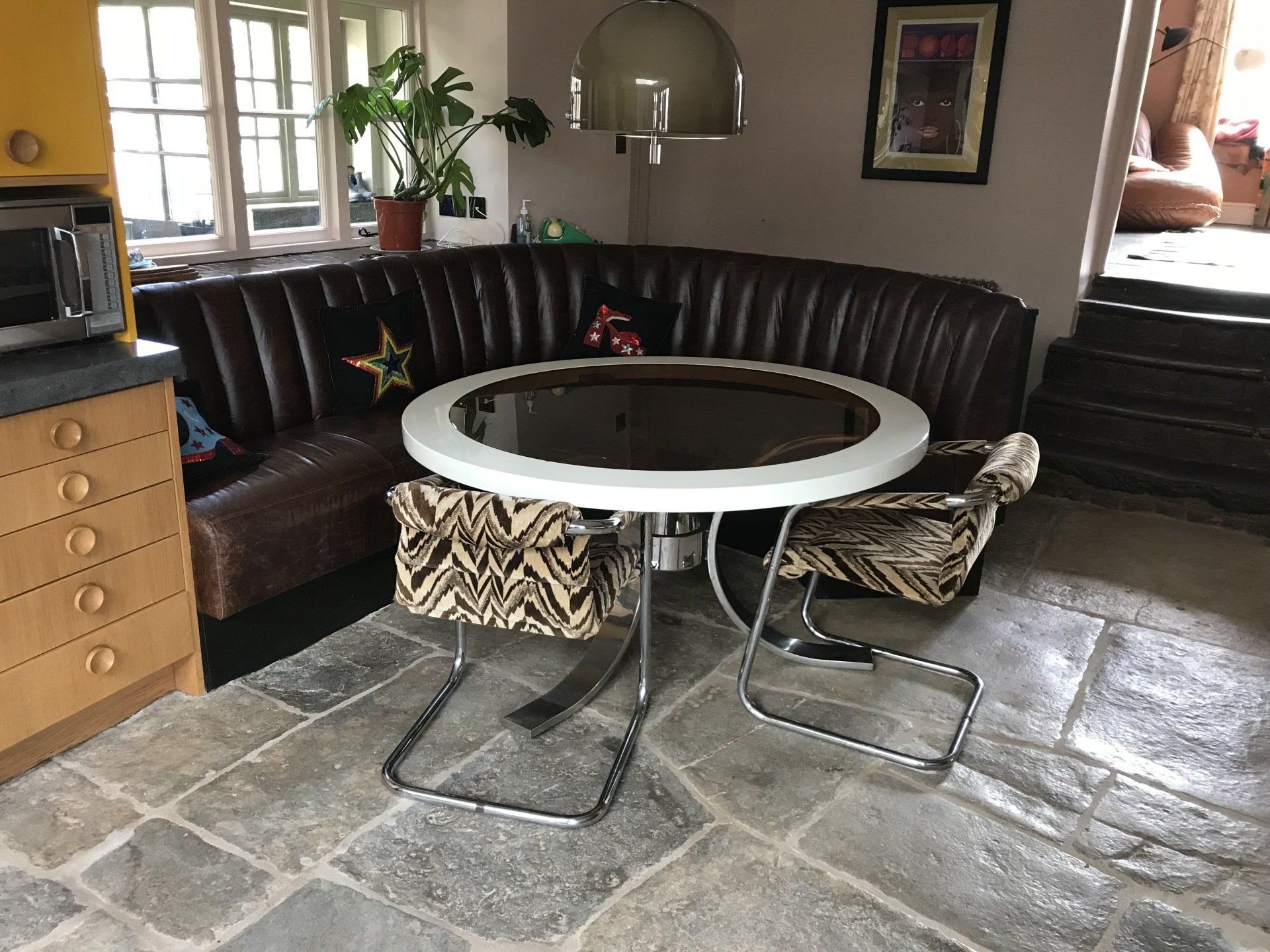 Banquette Seating leather with round table with flagstone floor and retro fabric chairs