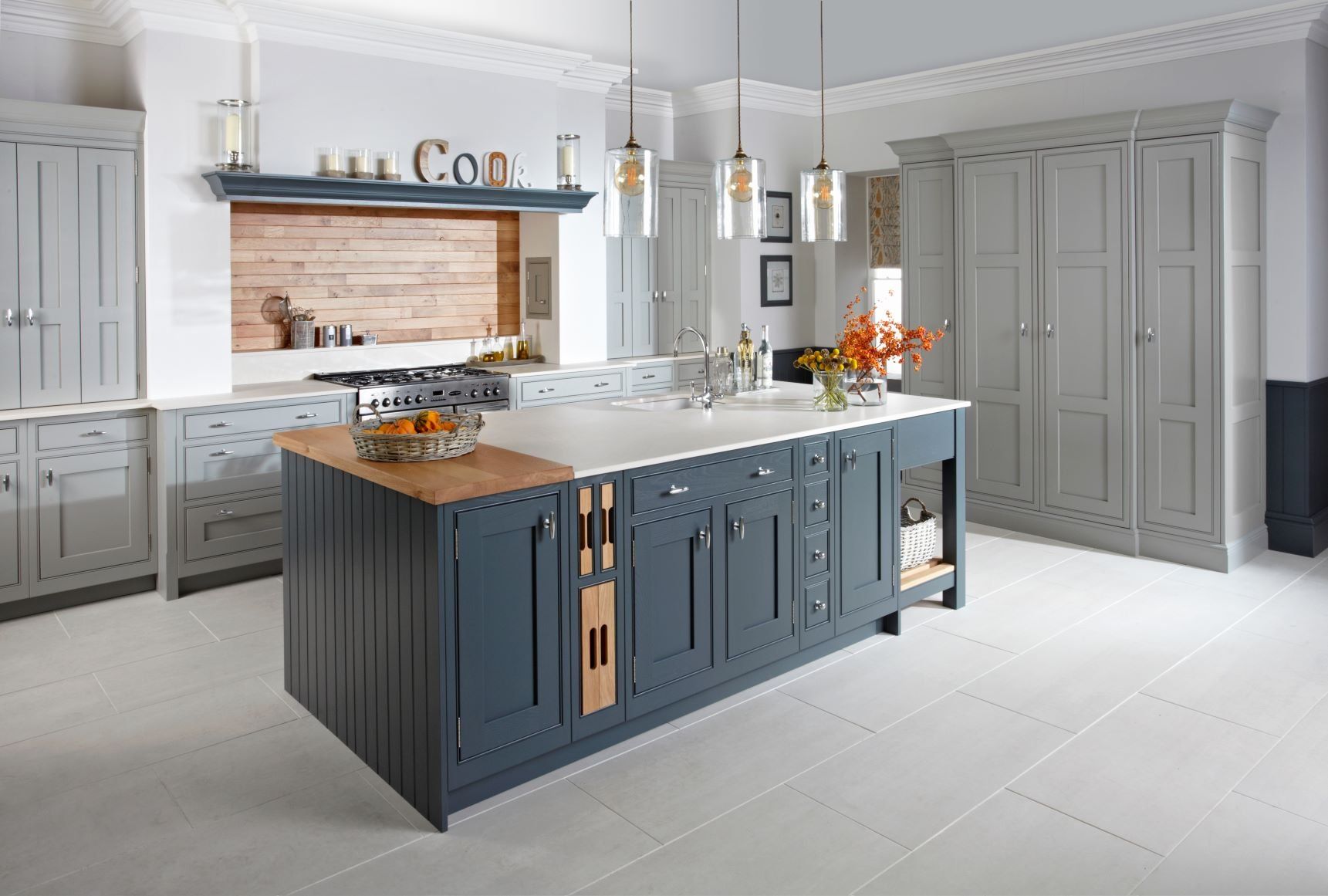 Langton Gravel and Seal Grey kitchen with large pale brick floor and wooden chopping board and tray set unit. Spice drawers.