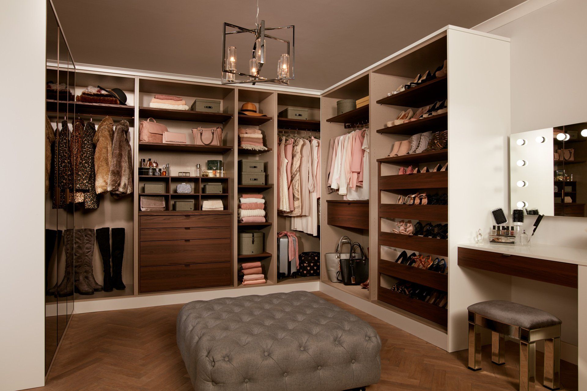 Walk-in wardrobe with walnut drawers and grey large  button covered stool