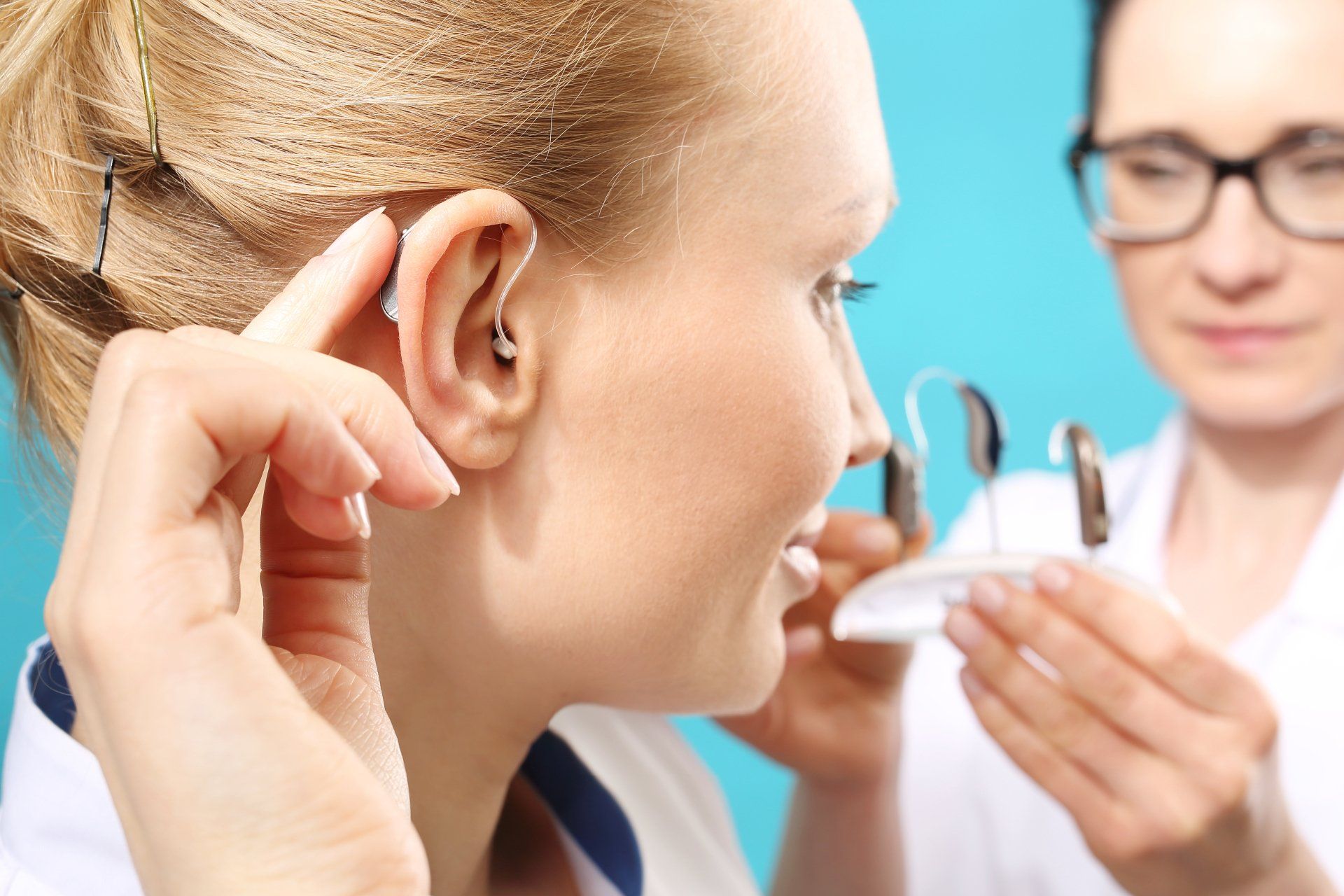 Inserting Hearing Aid in the Ear — Orange, MA — Leonard Optician Inc.
