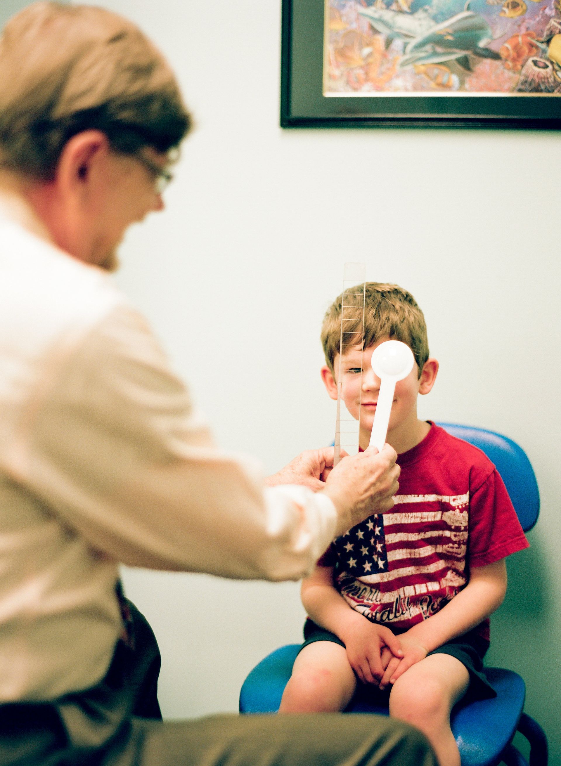 girl sitting on mother's lap receiving eye test
