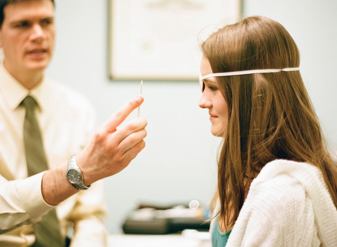 man receiving eye test with light shining in eye