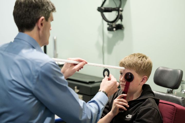 boy smiling and wearing eye test goggles