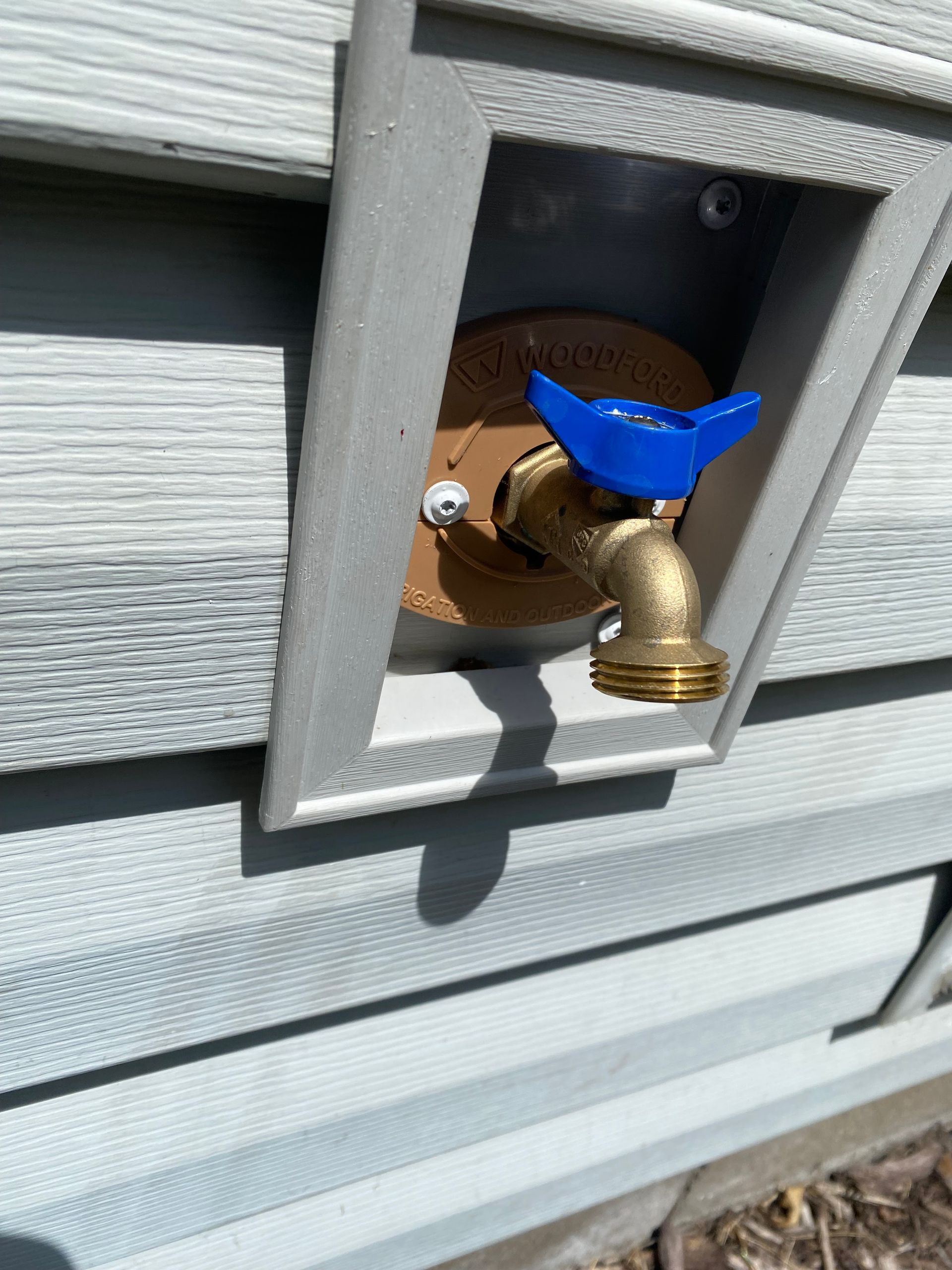 A close up of a faucet on the side of a house.
