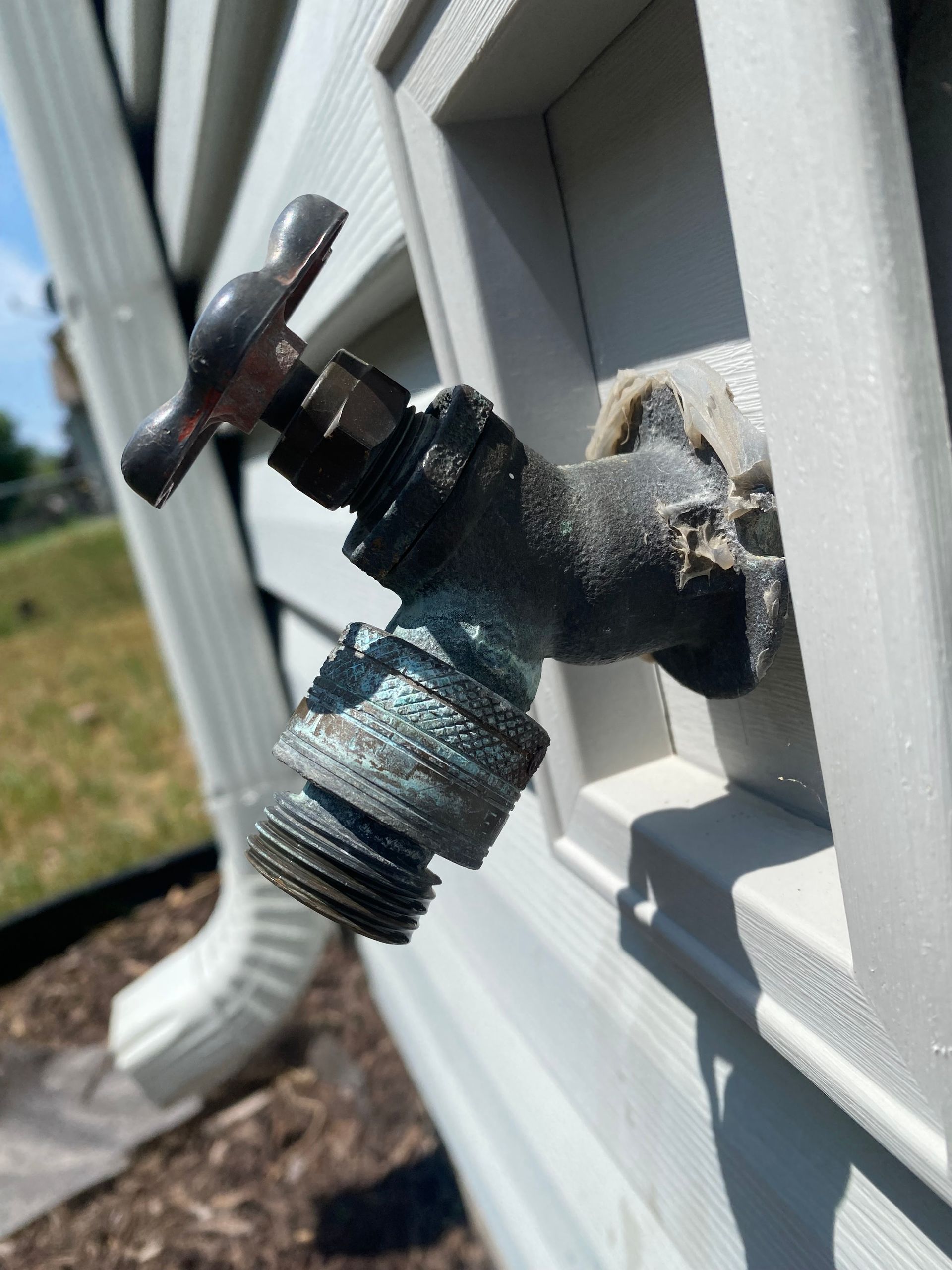 A close up of a faucet on the side of a house