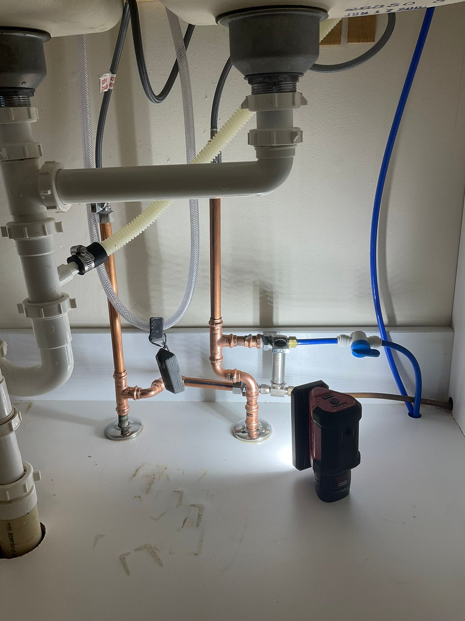 A sink with a lot of pipes underneath it.