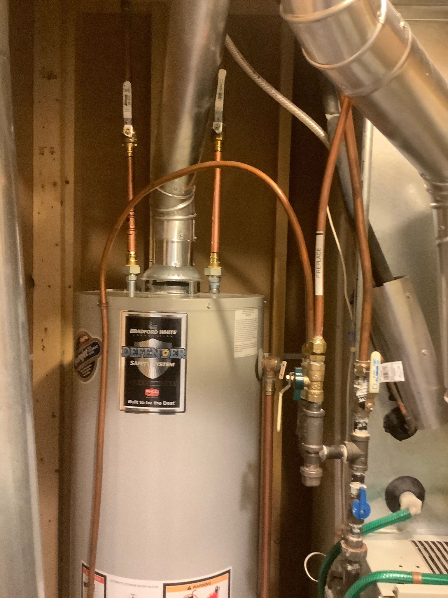 A water heater with copper pipes attached to it