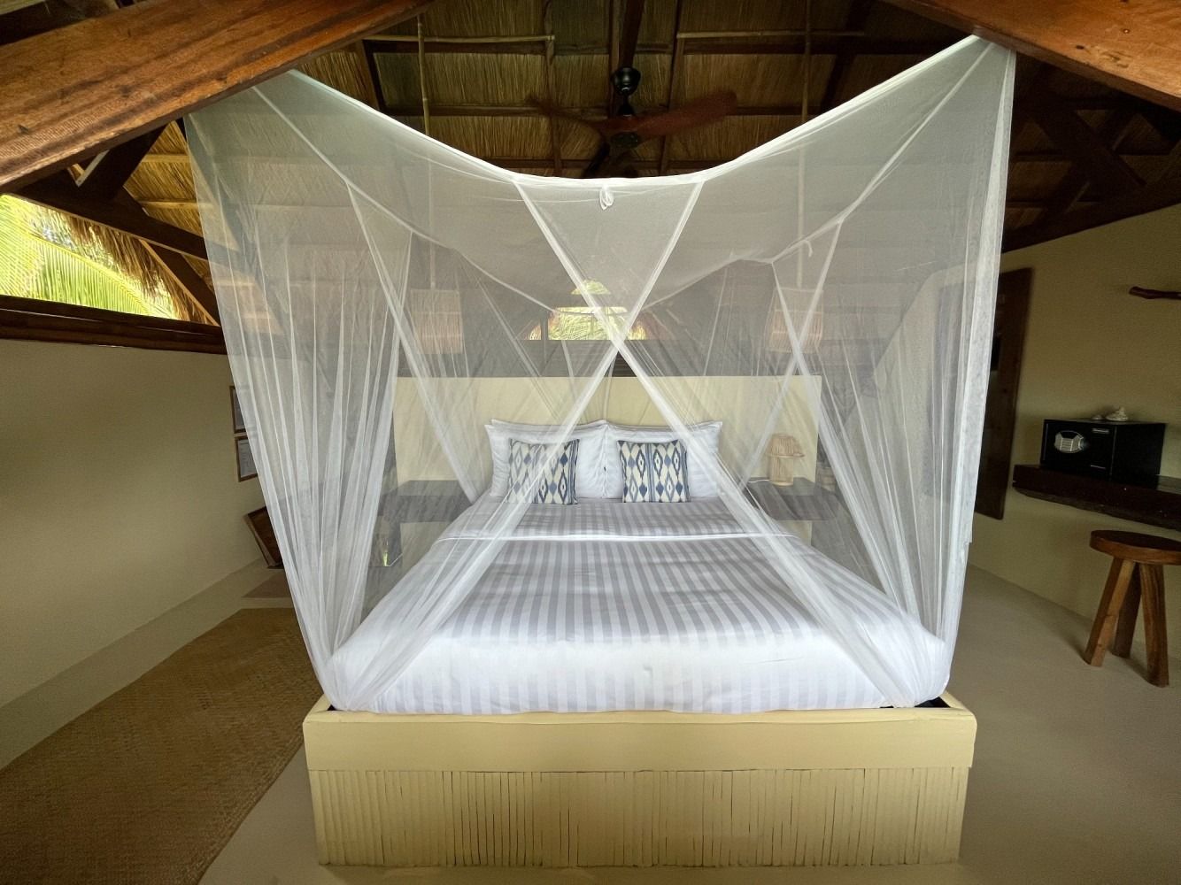 A bed with a mosquito net over it