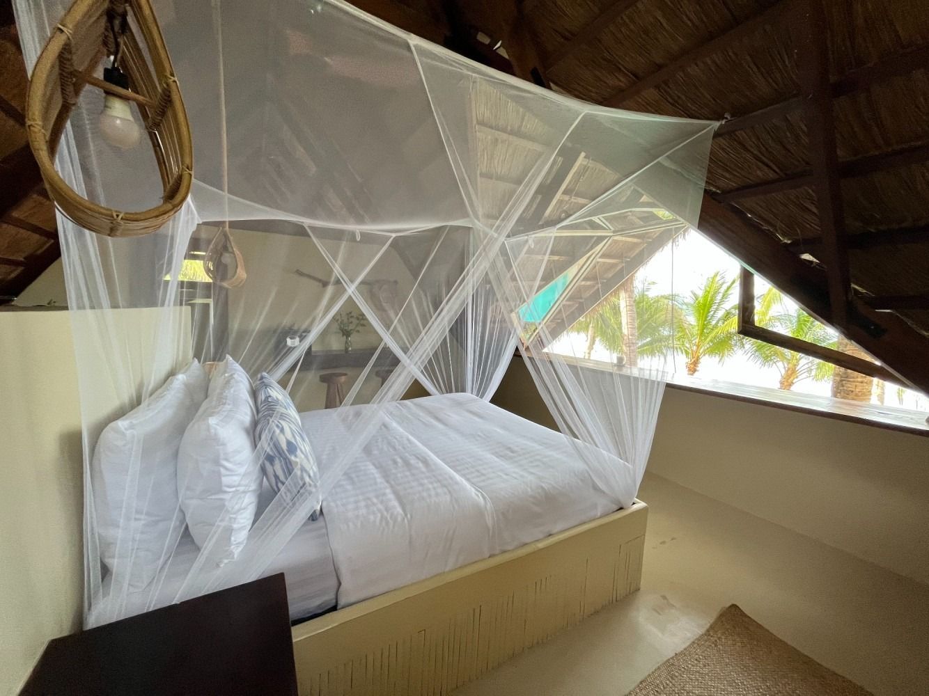A bedroom with a mosquito net over the bed.